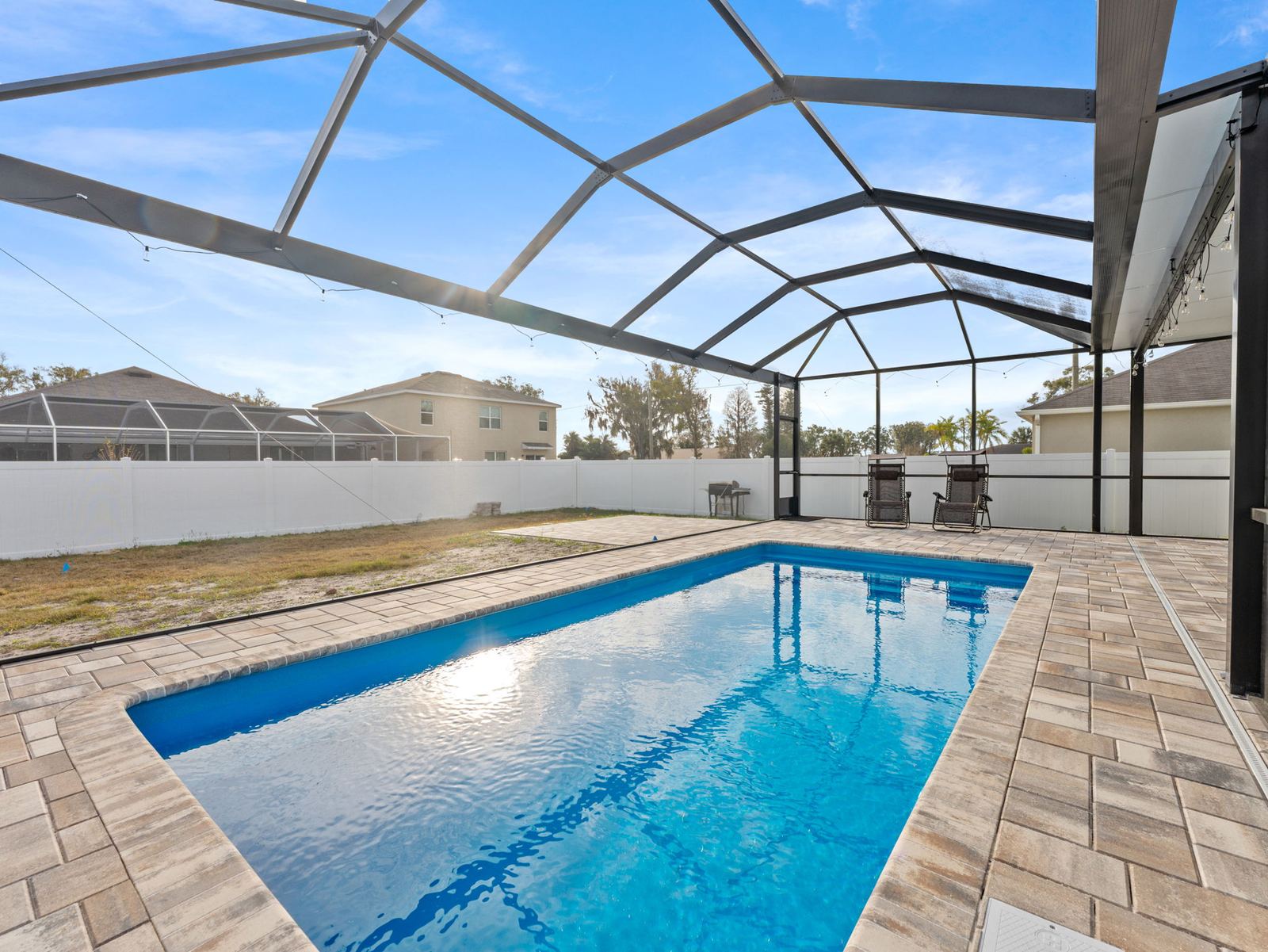 Rectangular pool with a paver deck in a screened lanai
